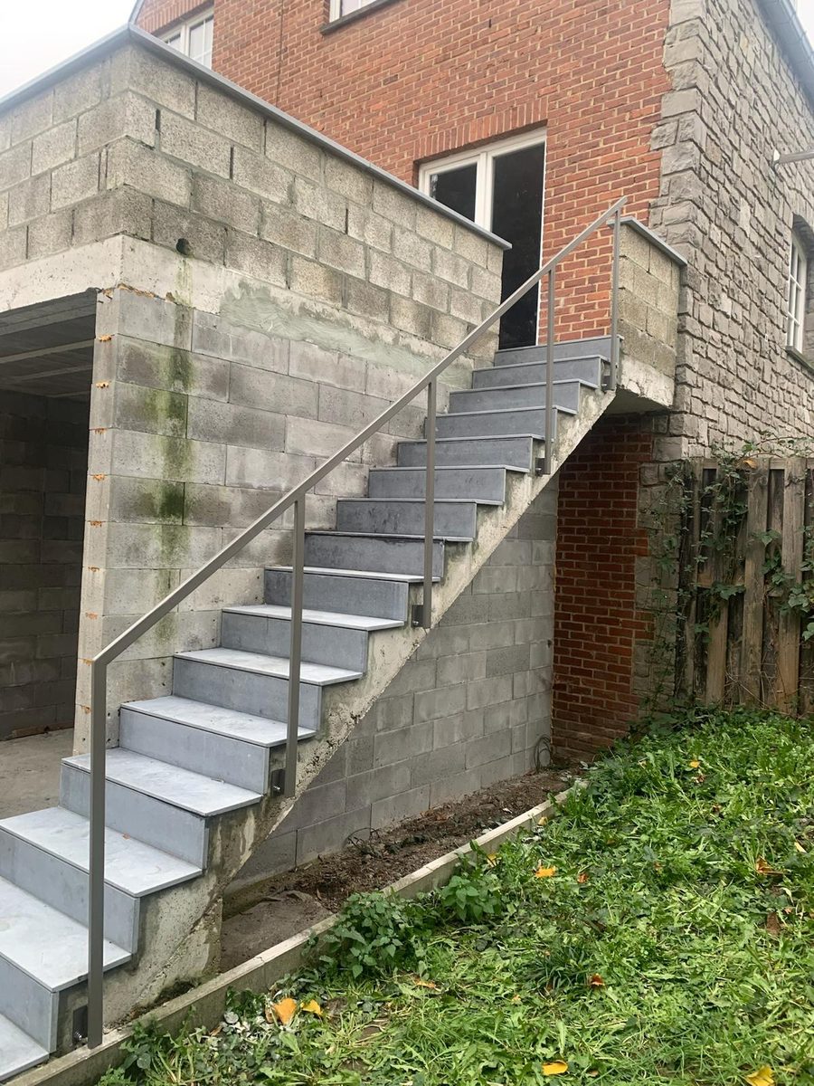 Rampe d'escalier en acier thermolaqué sur un escalier extérieur en pierre bleue